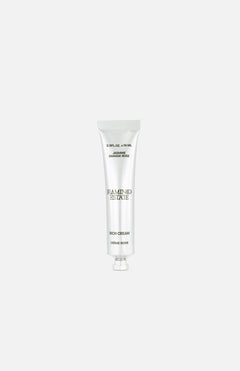 A silver tube labeled FLAMINGO ESTATE Jasmine Damask Rose Rich Cream, enriched with shea butter, stands upright on a plain white background, with text appearing above and below the product.