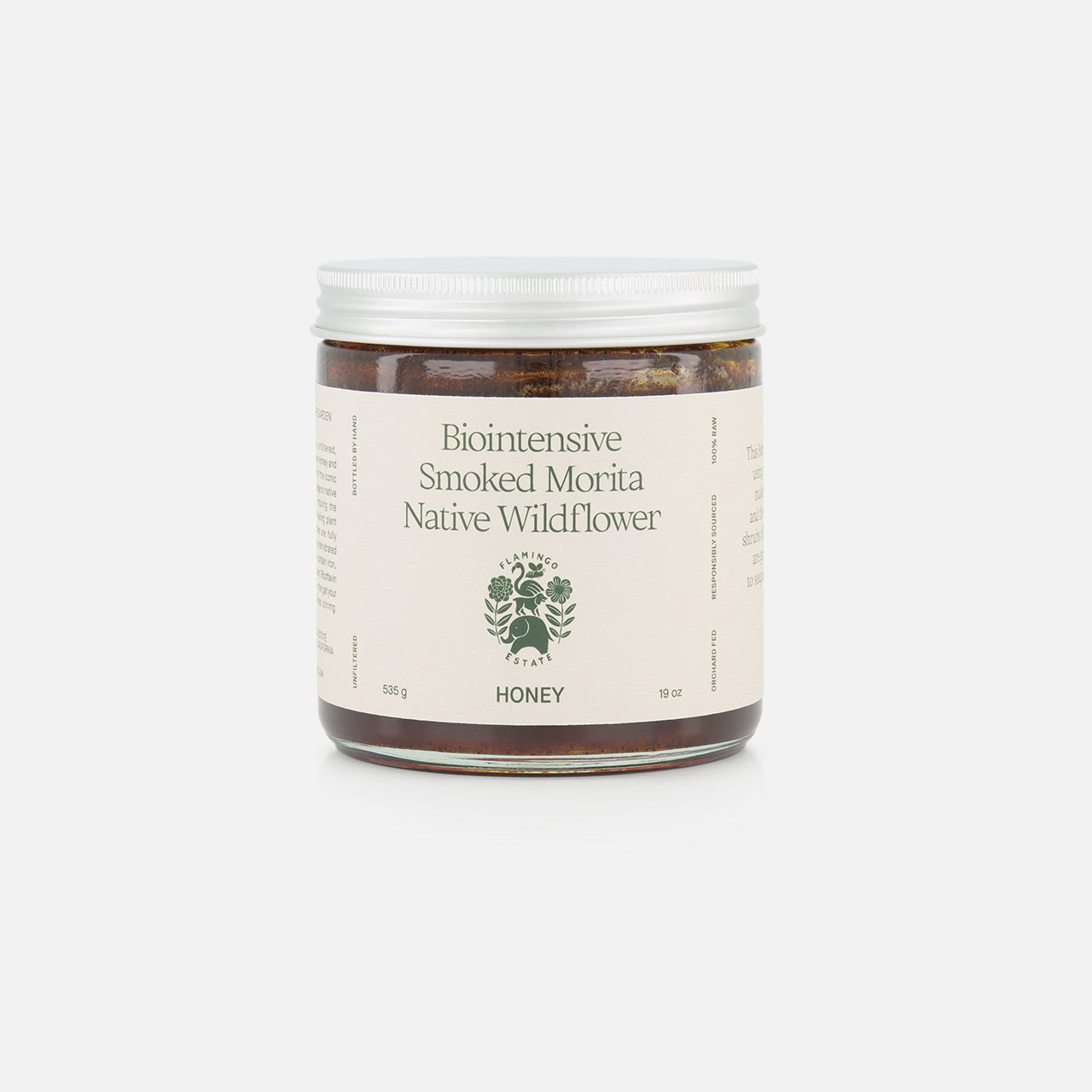 A 19 oz glass jar of FLAMINGO ESTATE Morita Chile Honey with a white lid, green wildflower illustration, and unfiltered honey infused with morita chile for a unique flavor.