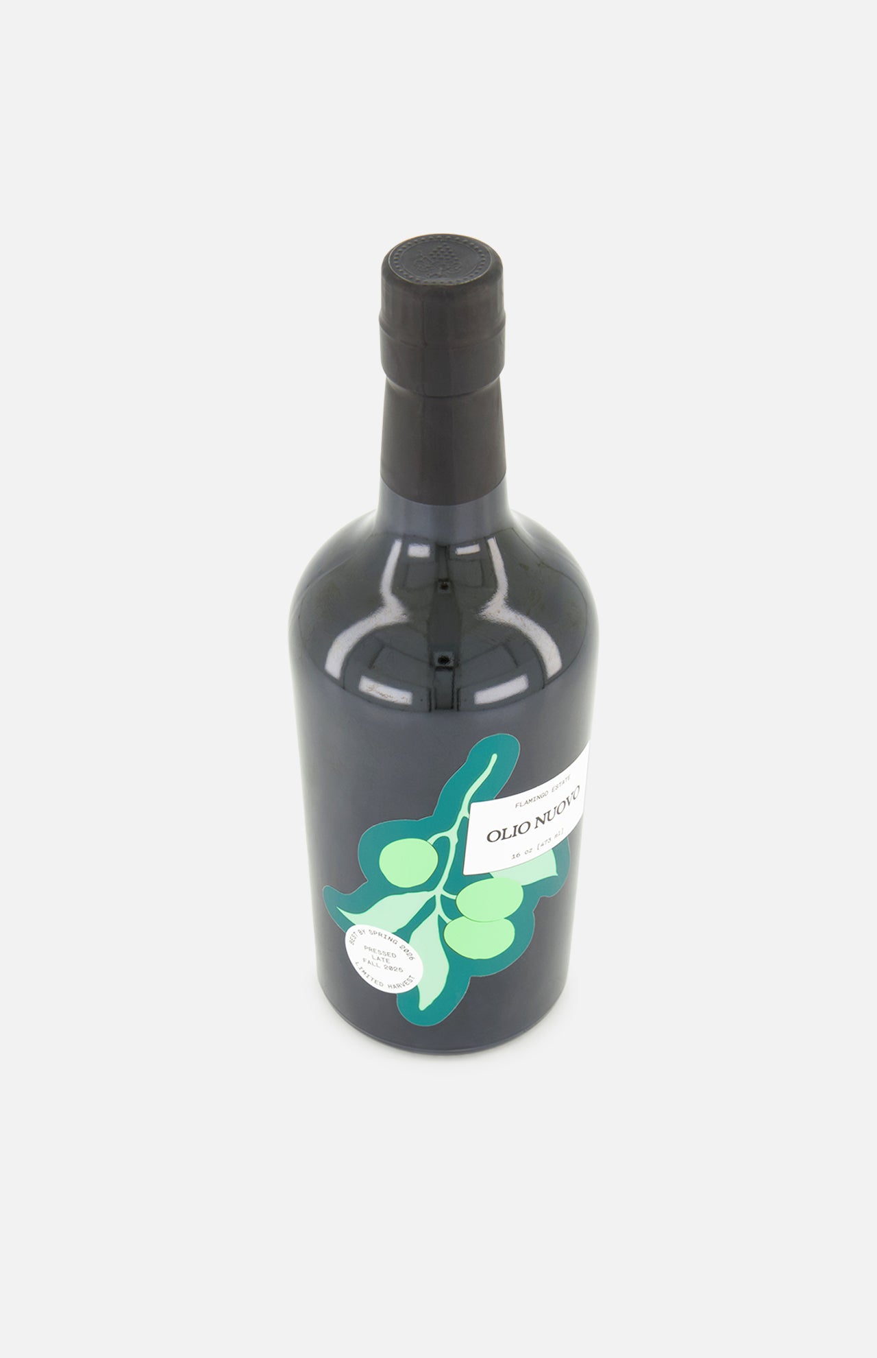 A dark glass 16 oz bottle of FLAMINGO ESTATE's Olio Nuovo features a black cap and modern label with green olive art and "OLIO NUOVO" on white. This limited edition Ojai, California olive oil is shown against a plain white background.