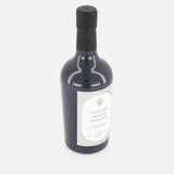 A dark glass bottle with a black cap and a white label reading FLAMINGO ESTATE White Truffle Extra Virgin Olive Oil sits on a white background, highlighting this premium offering.