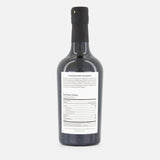 A FLAMINGO ESTATE White Truffle Extra Virgin Olive Oil bottle, dark glass with a black cap, is shown from the back. The white label with black text and nutrition facts stands out against a plain white background.