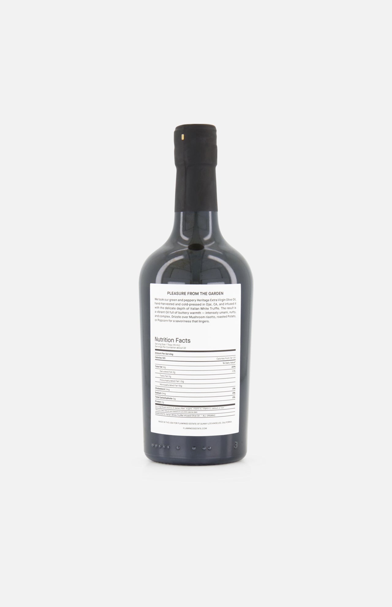 A FLAMINGO ESTATE White Truffle Extra Virgin Olive Oil bottle, dark glass with a black cap, is shown from the back. The white label with black text and nutrition facts stands out against a plain white background.