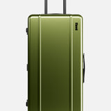 The Bold Suitcase by FLOYD features a hard olive green shell, telescoping handle, and four red skateboard-style spinner wheels, shown upright on a plain white background.