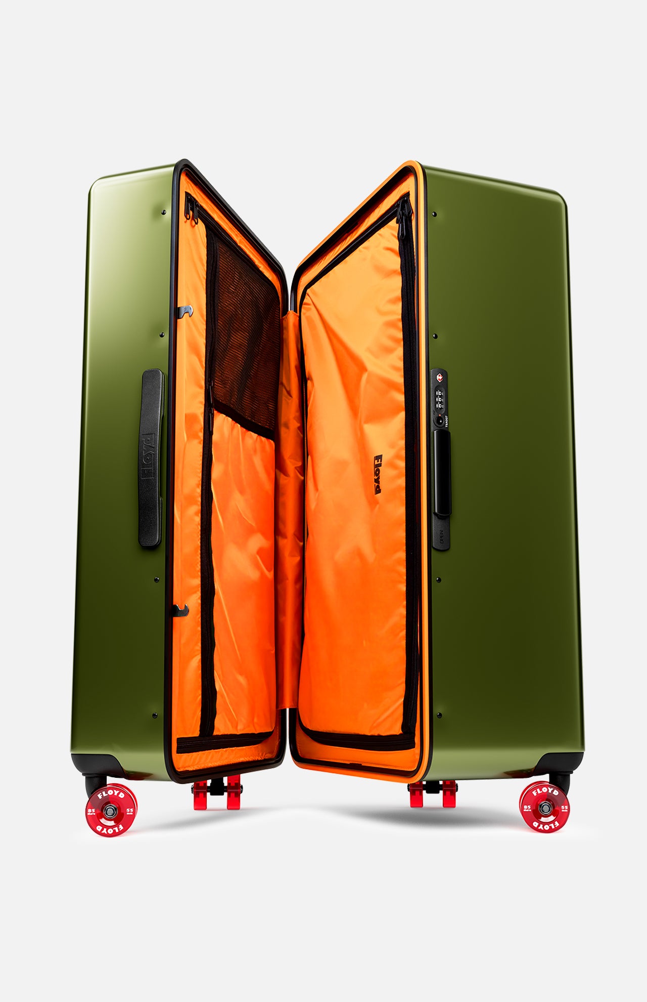 The Bold Suitcase by FLOYD is a large, open hard-top case in olive green with a bright orange interior, black mesh pockets, and red skateboard spinner wheels, shown upright against a white background.