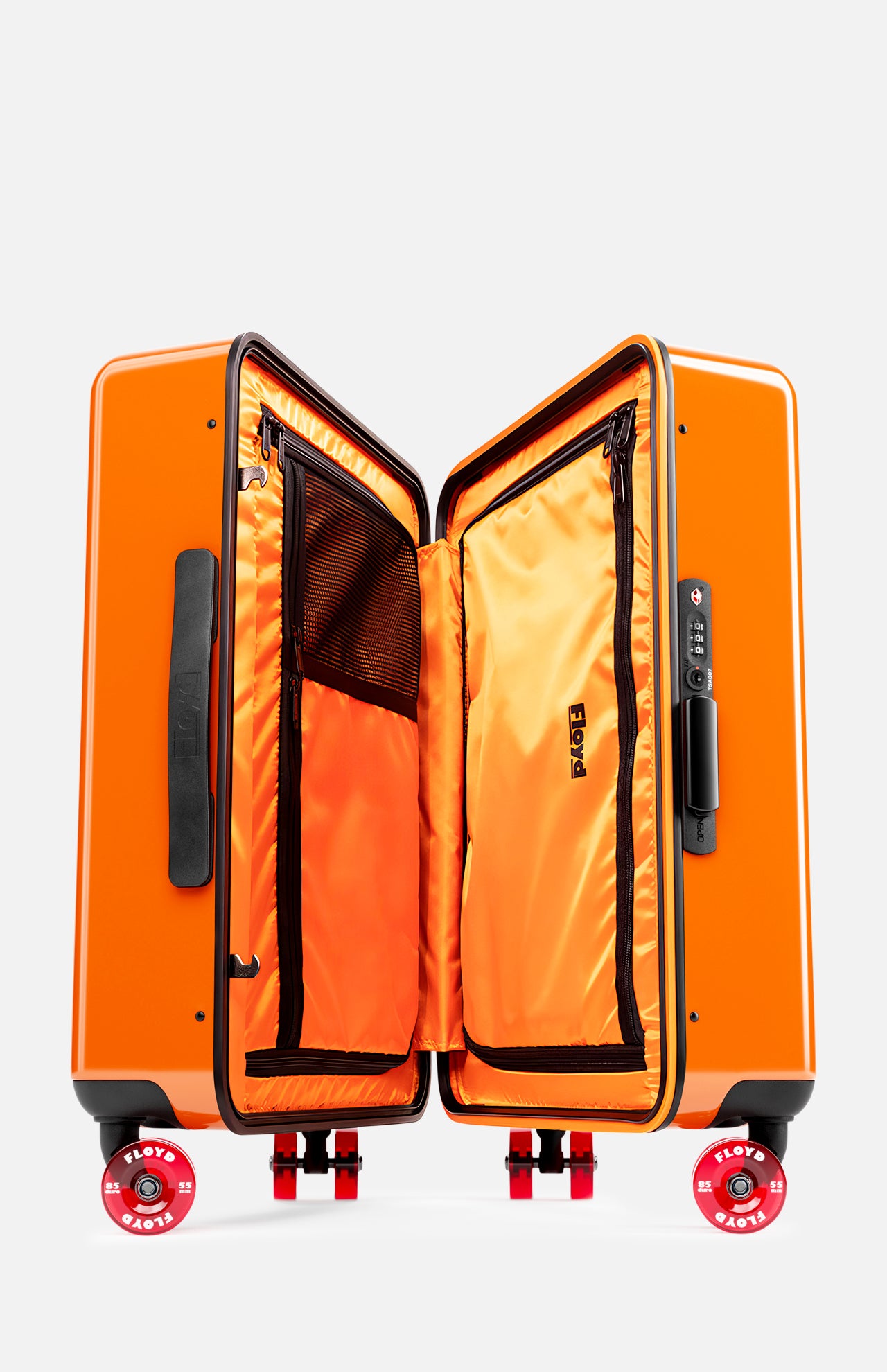 The Cabin Suitcase by FLOYD is shown upright and open, displaying its orange interior with zippered compartments and mesh pockets. It features a bright orange hard-top shell, black handles, and four skateboard spinner wheels with red FLOTE accents.