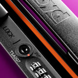 Close-up of FLOYD’s The Cabin Suitcase with a black hard-top, TSA007 code lock, circular keyhole, and “FLOYD” logo on the handle. Shown against a purple background with smooth 360° spinner wheels.