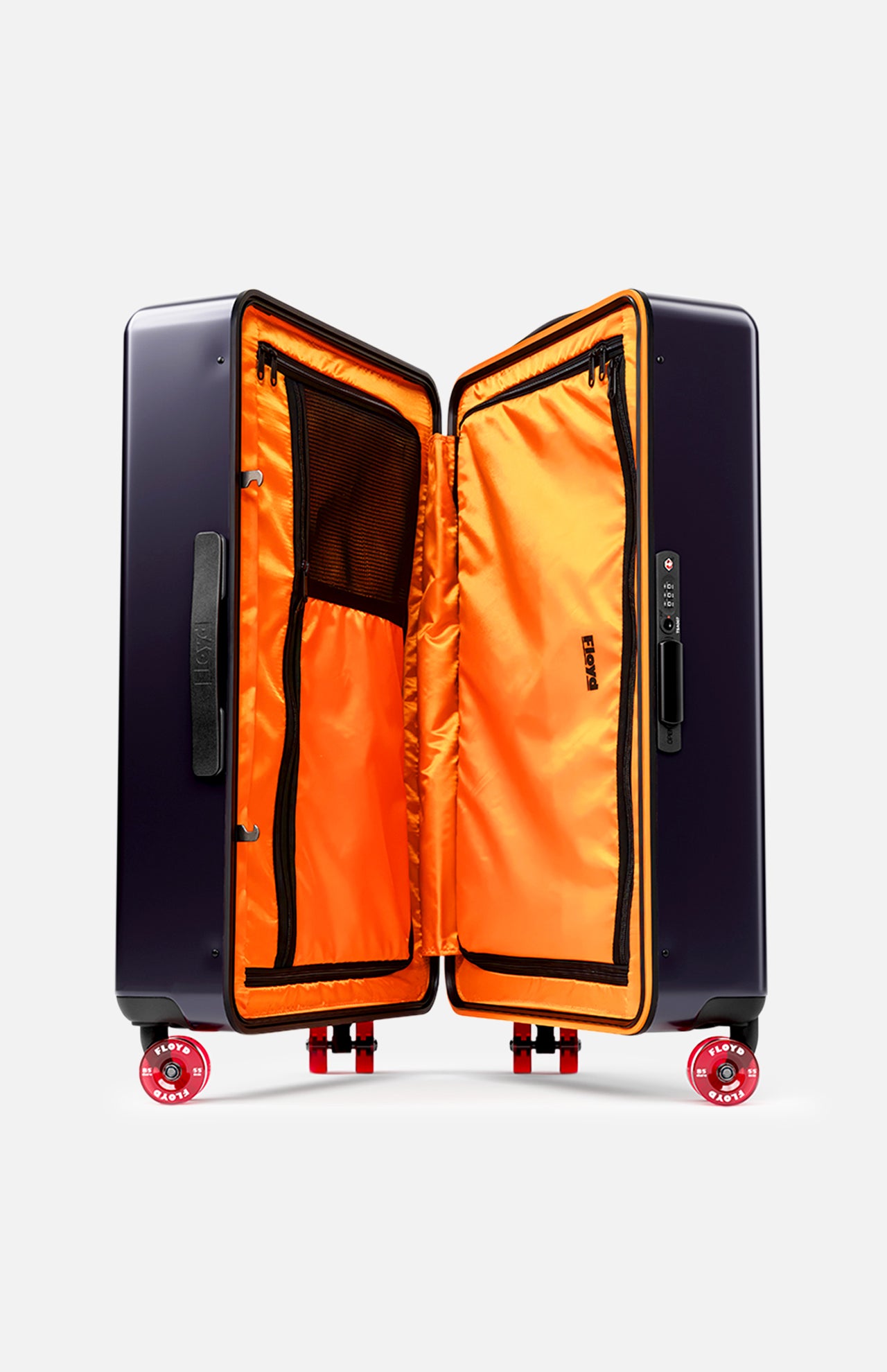 The Check-In Suitcase by FLOYD is a hard-top case with a dark exterior and bright orange interior, open to show mesh and zippered compartments. It features 360° spinner wheels and a built-in TSA lock for secure travel.