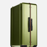 The Check-In Suitcase by FLOYD is a hard-top olive green suitcase with a black handle, orange zipper line, TSA lock, and red skateboard spinner wheels, shown upright on a white background.