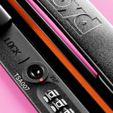 Close-up of the FLOYD Check-In Suitcase lock featuring a combination dial, TSA007 keyhole, and orange accent. "FLOYD" is embossed on the handle against a pink background.