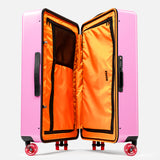 The FLOYD Check-In Suitcase features a hard pink shell, a vibrant orange interior with zippered mesh compartments, black handles, and four 360° spinner wheels.