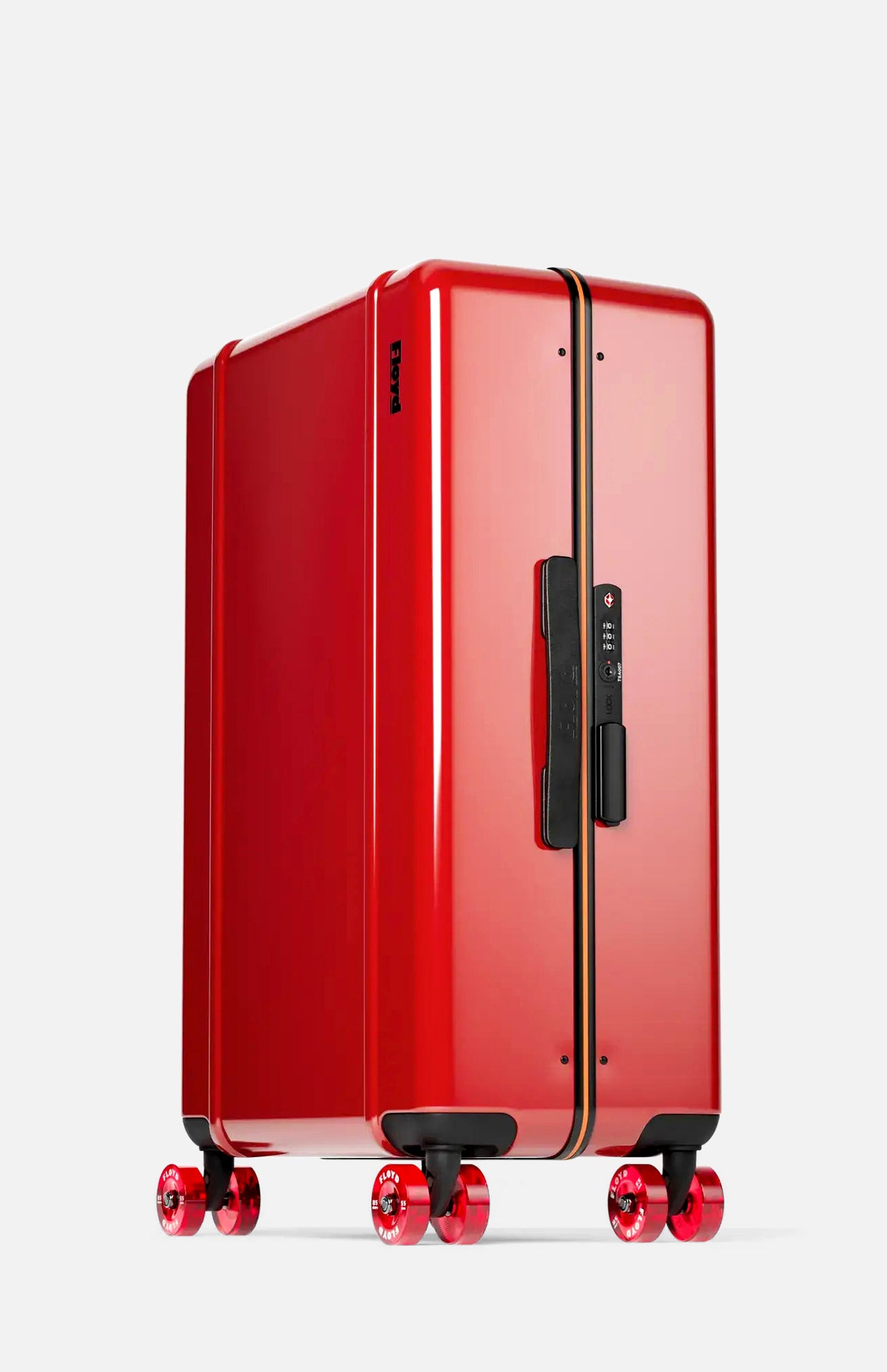 Standing upright against a light gray background, the FLOYD Check-In Suitcase features a sleek, shiny red hard-top design accented by a central gold and black stripe, four skateboard-style spinner wheels, and a black handle.