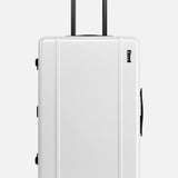 The Check-In Suitcase by FLOYD is a white hard-top with a black telescopic and side handle, distinctive red skateboard spinner wheels, and the FLOYD logo printed near the top right.