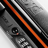 Close-up of the locking mechanism on FLOYD’s The Check-In Suitcase, showing a black TSA lock with combination dial, TSA007 keyhole, orange trim, and the FLOYD name embossed on the surface.