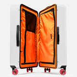 The Check-In Suitcase by FLOYD is a white hard-top case with skateboard spinner wheels. Its open lid reveals a vibrant orange interior featuring zippered mesh pockets and organized compartments.