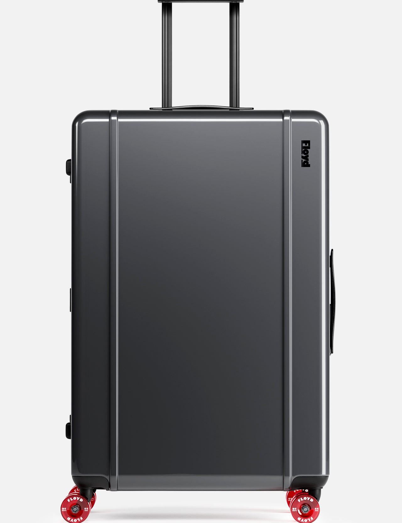The Trunk Suitcase by FLOYD is a hard-top, dark gray suitcase featuring four red skateboard spinner wheels, a black side handle, and an extended black telescopic handle, displayed on a plain white background.