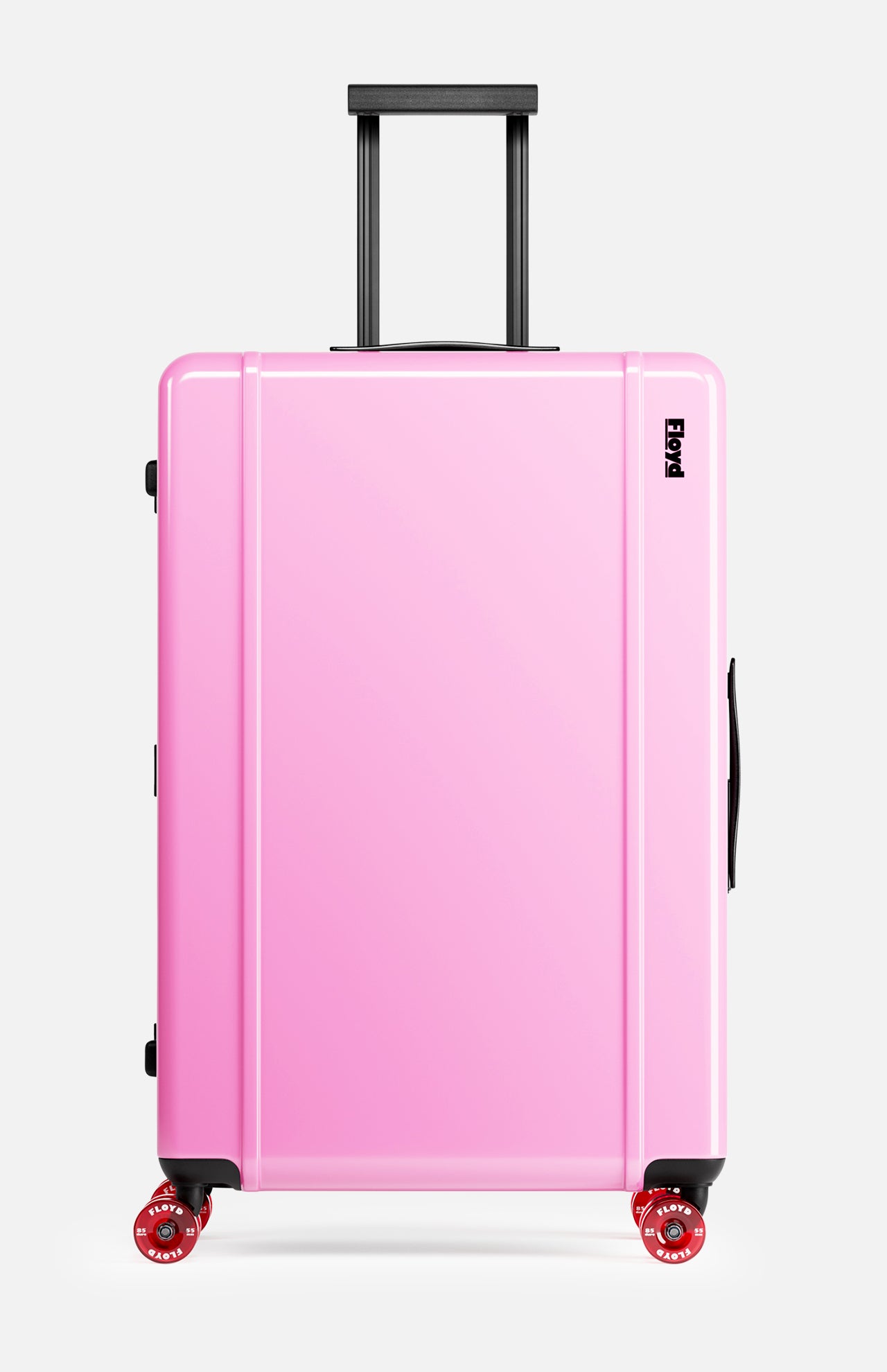 The Trunk Suitcase by FLOYD is a hard-top, pink rolling suitcase with a black handle and four 360° spinner wheels, pictured upright against a plain white background.