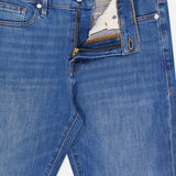 A pair of Frame L’Homme Slim Jeans in Verdugo, crafted from premium stretch denim in dark blue, featuring a slim fit silhouette with a partially open zipper and button fly that reveals the FRAME-branded waistband label.