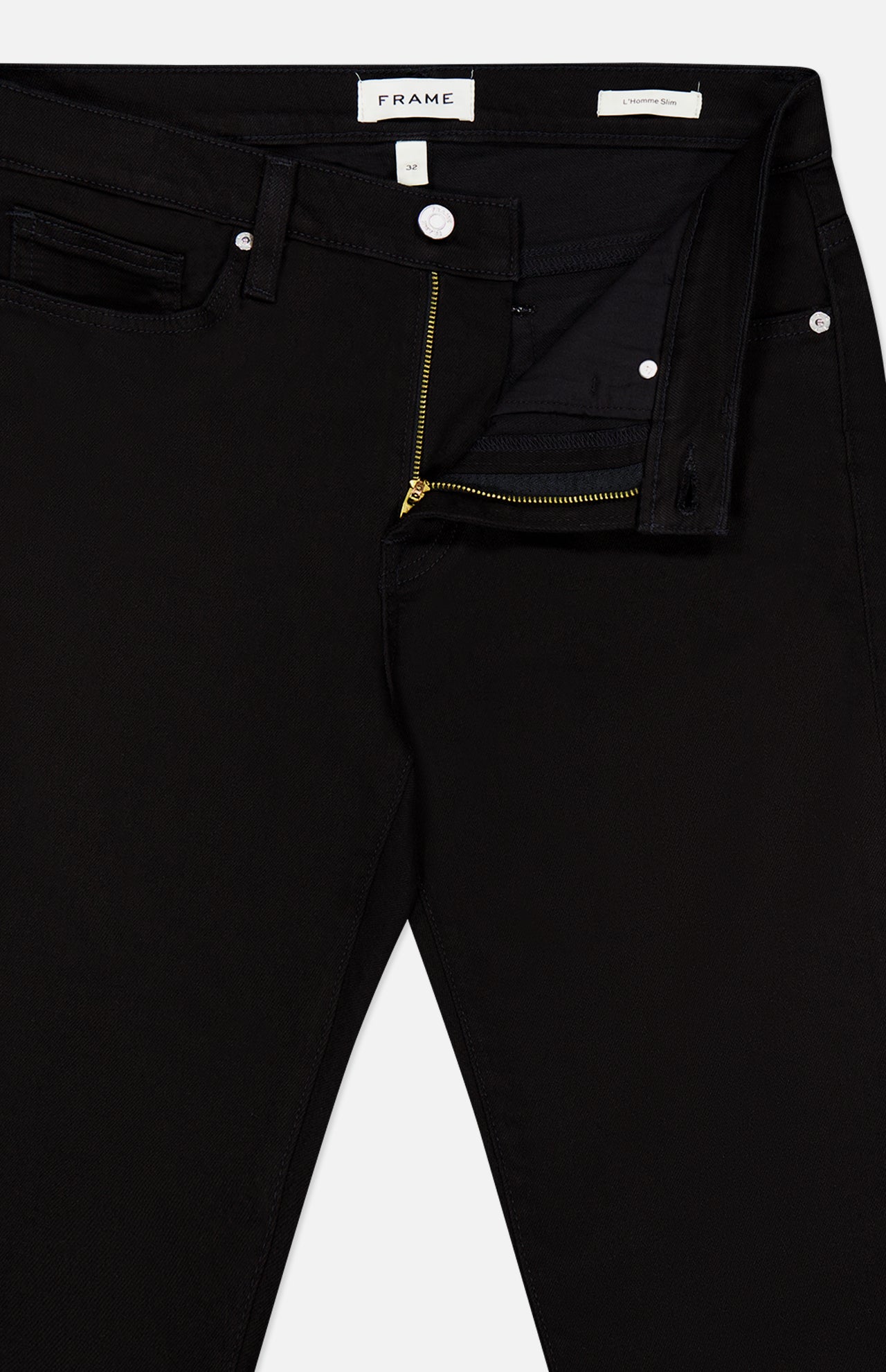 L’Homme Slim Pant in Noir by Frame, crafted from stretch denim, features a partially open zipper and unbuttoned waistband that reveals the inside label and pocket details. Designed in a modern slim fit for a sleek silhouette.
