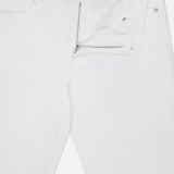 Introducing the L’Homme Slim Pant in Whisper White by Frame—crafted from premium stretch denim, these white jeans offer a slim fit silhouette with a partially unzipped fly and an open waistband that reveals the FRAME brand label inside.