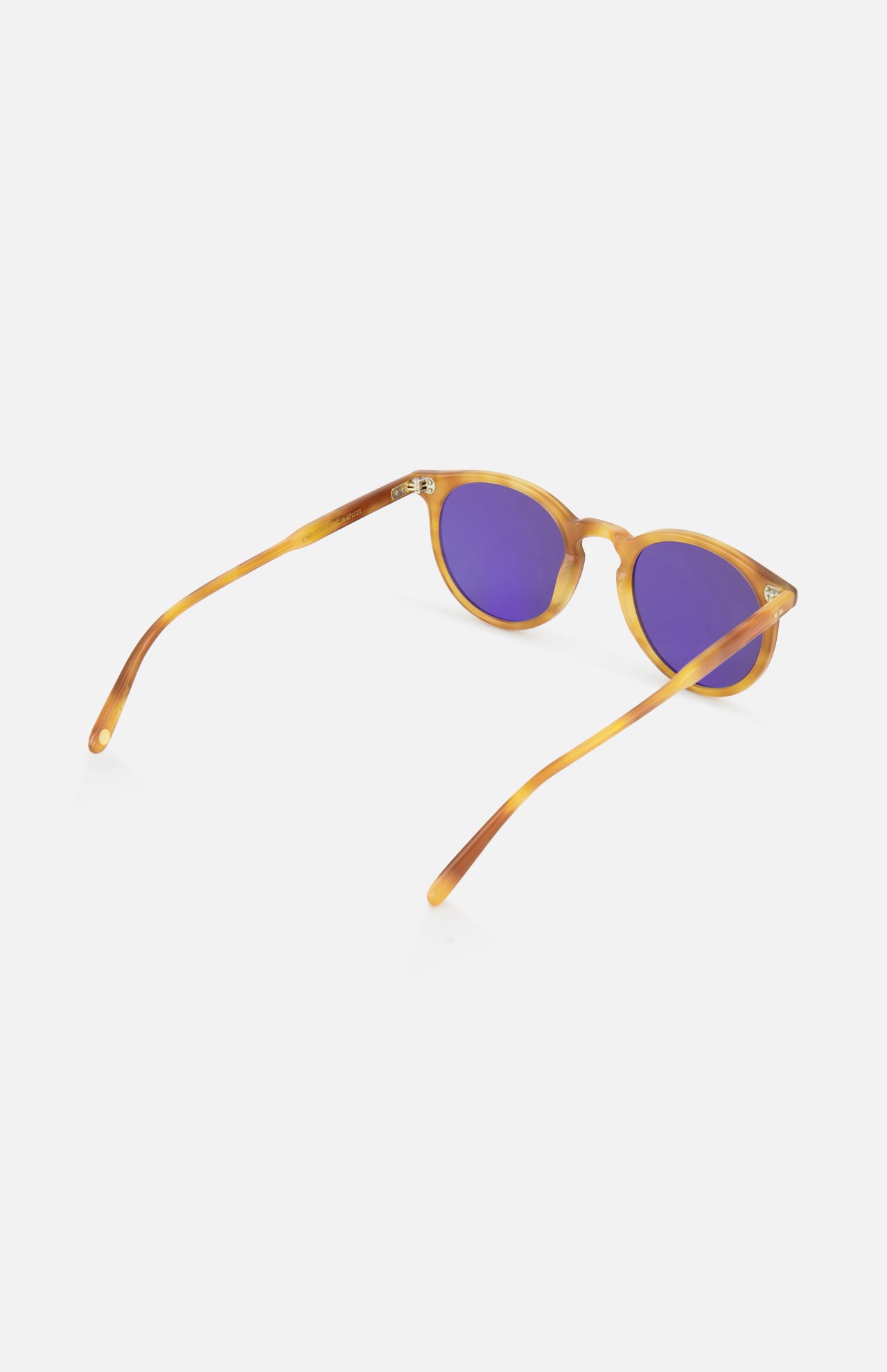 The GARRETT LEIGHT Carlton Round Tan Sunglasses feature purple-tinted lenses and bio-based acetate frames, displayed at an angle with open arms on a white background.