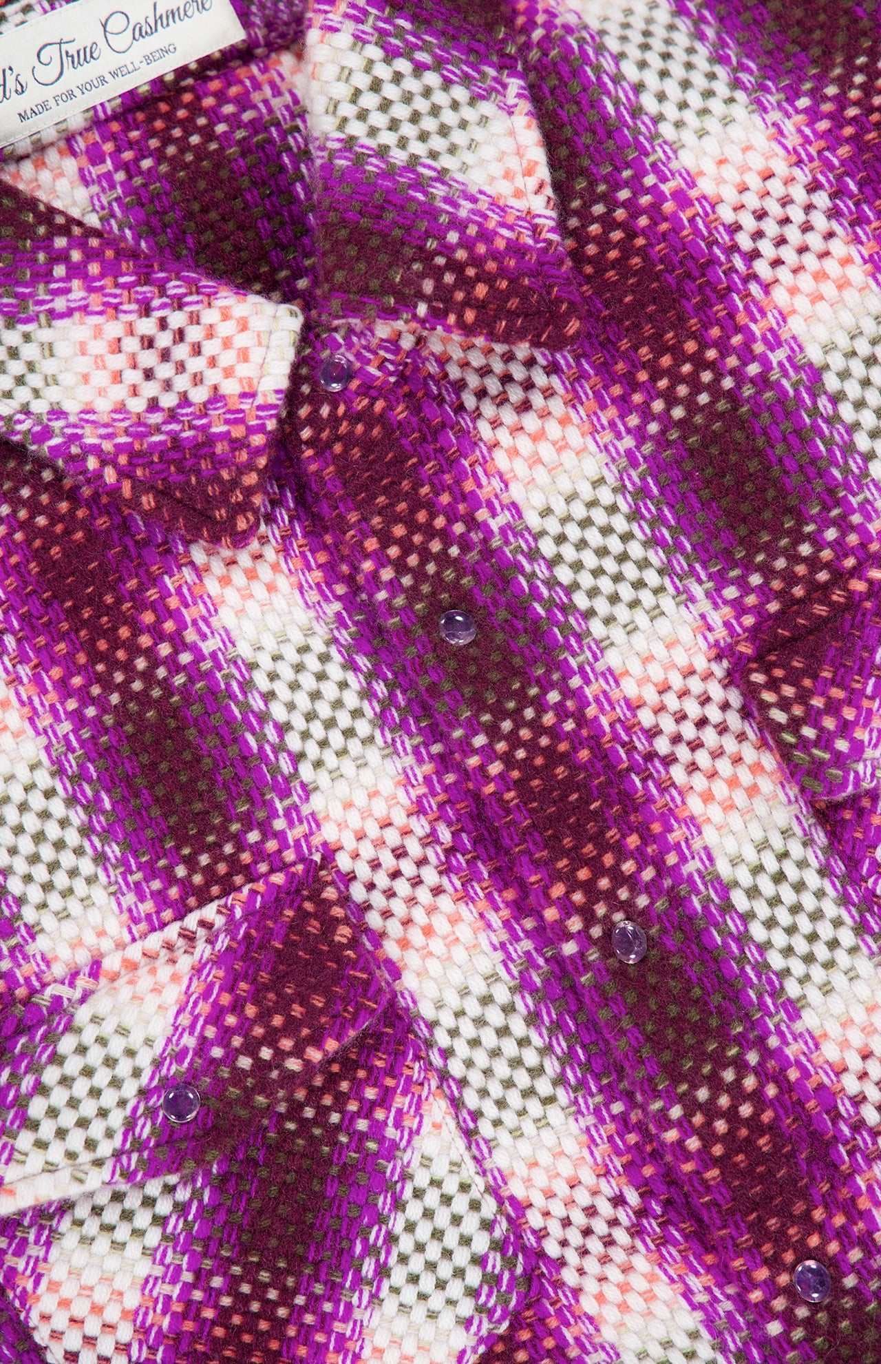 Close-up of a Frontier Plaid Cashmere Shirt by God’s True Cashmere in purple, white, and coral with amethyst gemstone snaps.