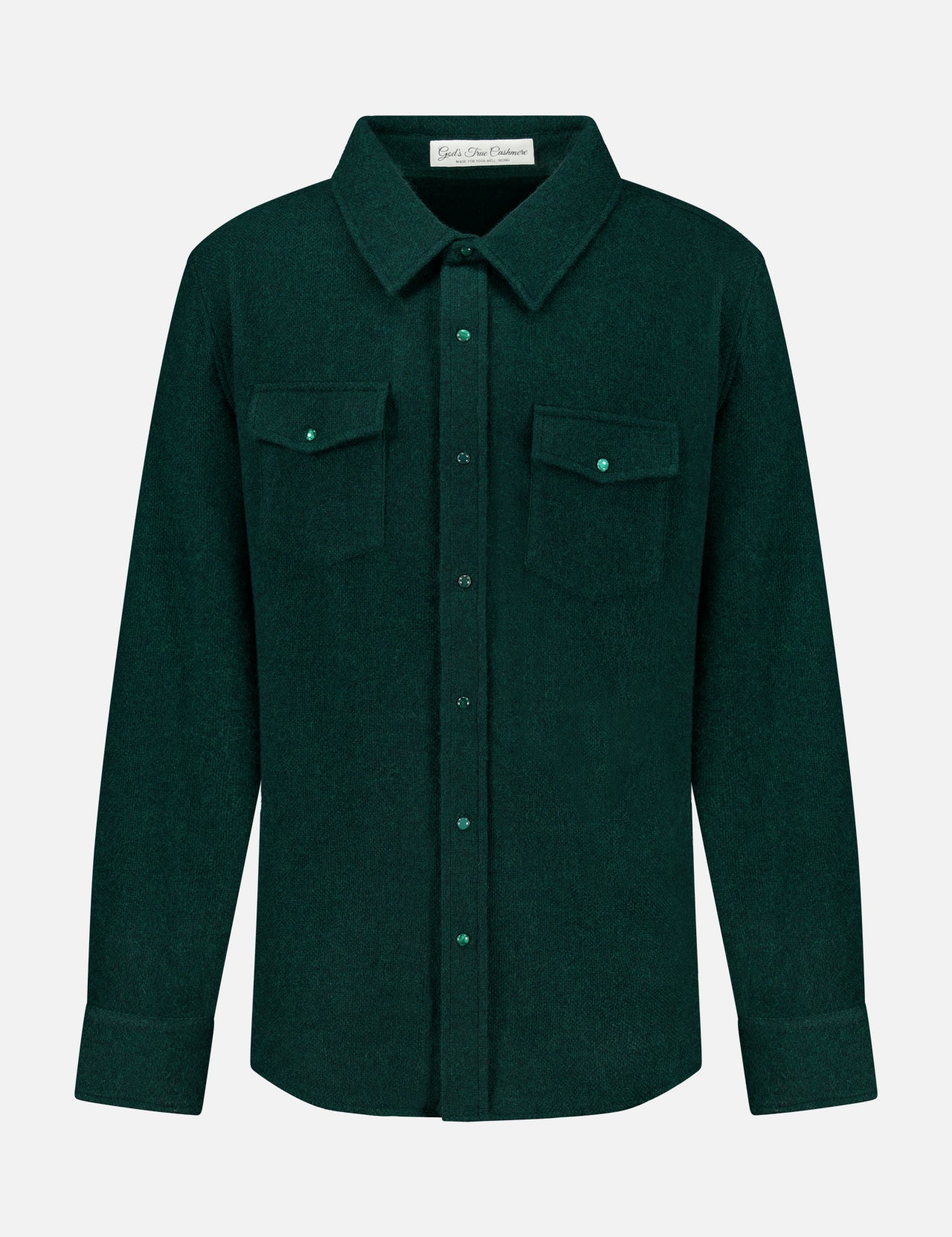 The Solid Cashmere Shirt with Malachite Buttons by God’s True Cashmere is a dark green unisex button-up featuring long sleeves, a pointed collar, adjustable cuffs, and two chest pockets with flaps and malachite buttons. Expertly crafted from soft cashmere for a luxurious feel, it is displayed against a plain white background.