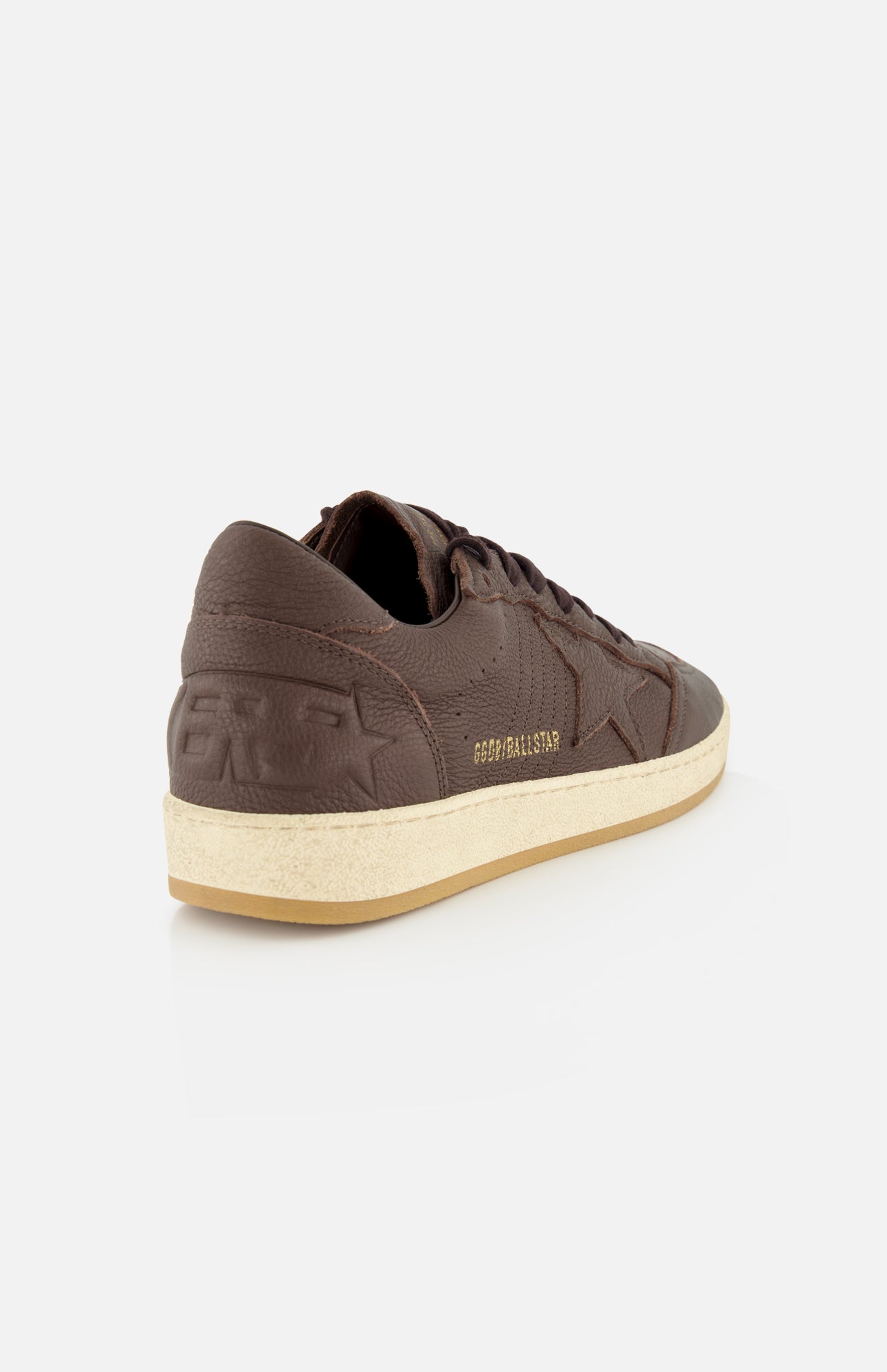 The GOLDEN GOOSE Ballstar Leather Upper Sneaker features a brown low-top design with a beige scuffed sole and embossed star and text details, shown from the back left side against a white background—a classic silhouette inspired by iconic Golden Goose style.