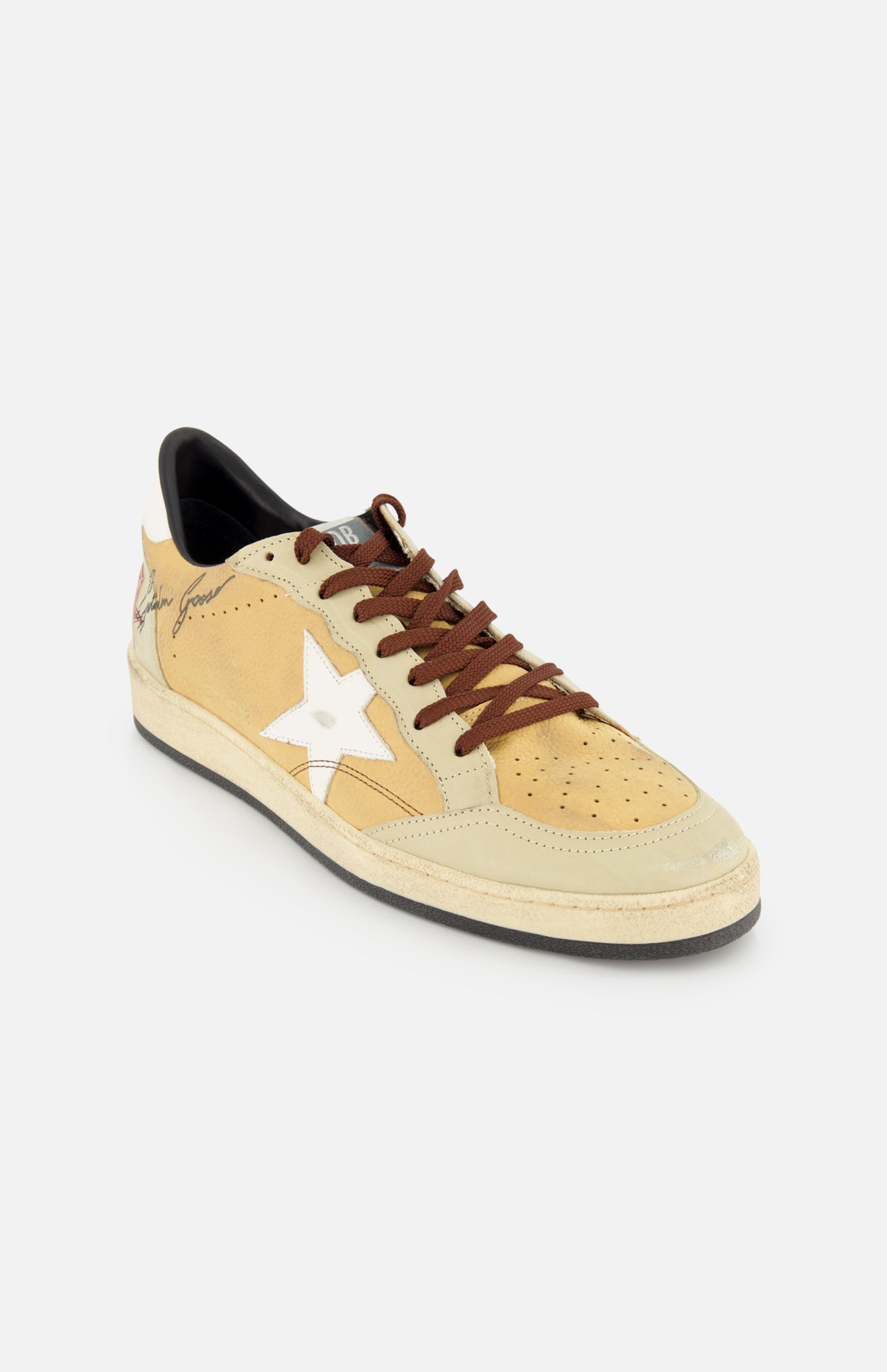 The GOLDEN GOOSE Ballstar Nabuk Upper And Tongue Sneaker is a tan and cream casual shoe with a white star on the side, brown leather laces, and a black sole, shown on a white background.