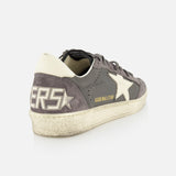 The GOLDEN GOOSE Ballstar Nabuk Upper Suede Sneaker for men features gray and white leather, a large star on the side, gold GGDB/BALLSTAR text, stylized SNEAKERS on the heel, and a worn vintage look.