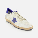 A GOLDEN GOOSE Ballstar Nappa Upper Sneaker in white leather features a blue star on the side, a scuffed sole, cream laces, and a blue heel detail in the brand’s signature style, photographed against a white background.