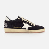 The GOLDEN GOOSE Ballstar Suede Upper Sneaker features a black low-top design, beige laces, an off-white star, gold GGDB/BALLSTAR text, a scuffed sole, and a graphic star with GGDB lettering on the heel.