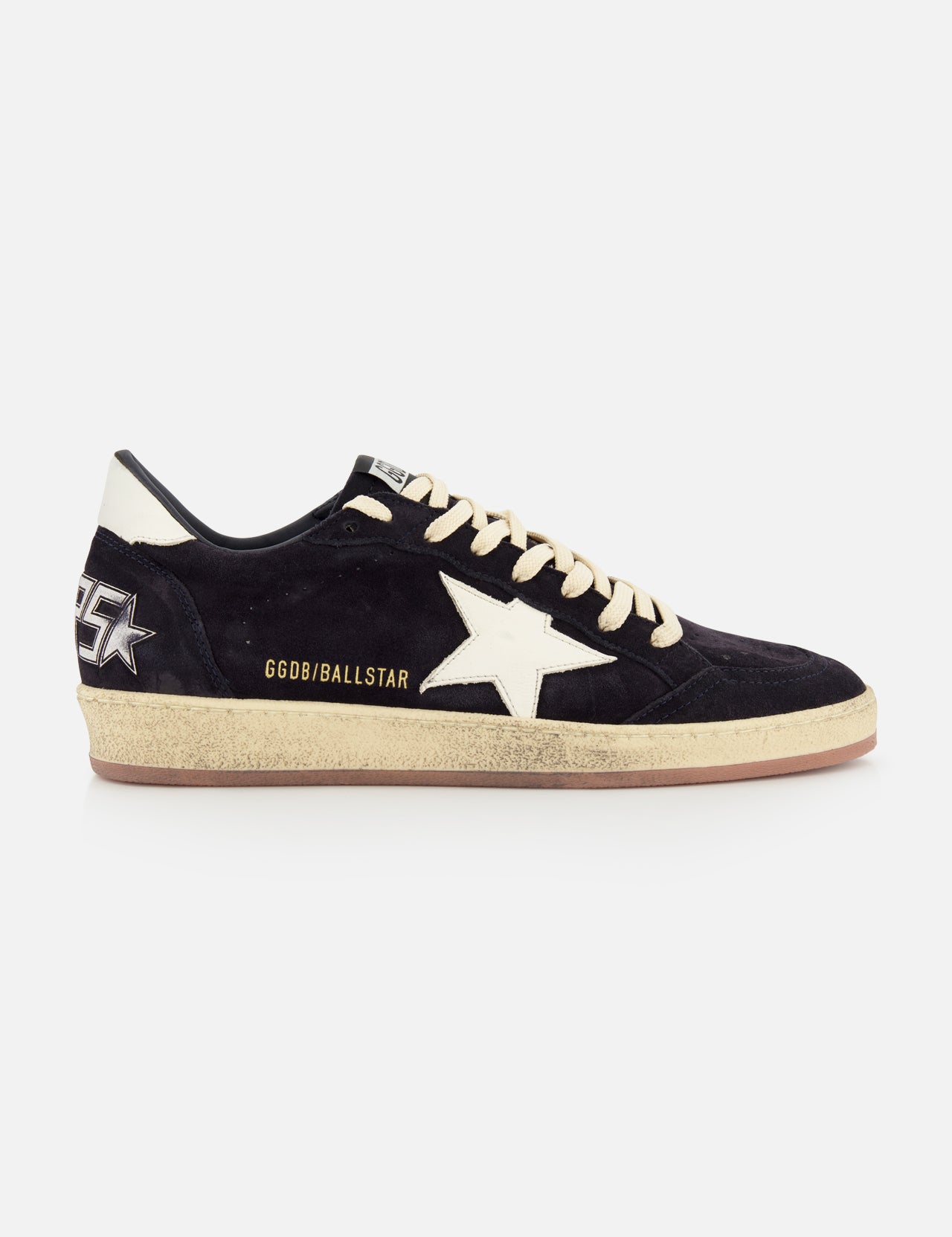 The GOLDEN GOOSE Ballstar Suede Upper Sneaker features a black low-top design, beige laces, an off-white star, gold GGDB/BALLSTAR text, a scuffed sole, and a graphic star with GGDB lettering on the heel.