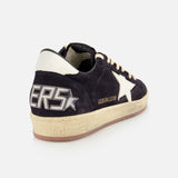 The GOLDEN GOOSE Ballstar Suede Upper Sneaker features a black and navy suede upper, white heel tab, large white star on the side, bold SNEAKERS lettering on the back, and an off-white scuffed sole for a signature worn-in vibe.