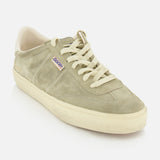 The Soul-Star Suede Sneaker by GOLDEN GOOSE is shown as a single taupe suede shoe with cream laces and a matching cream sole, accented by a subtle purple and white Gosha tag on the side, set against a plain white background.