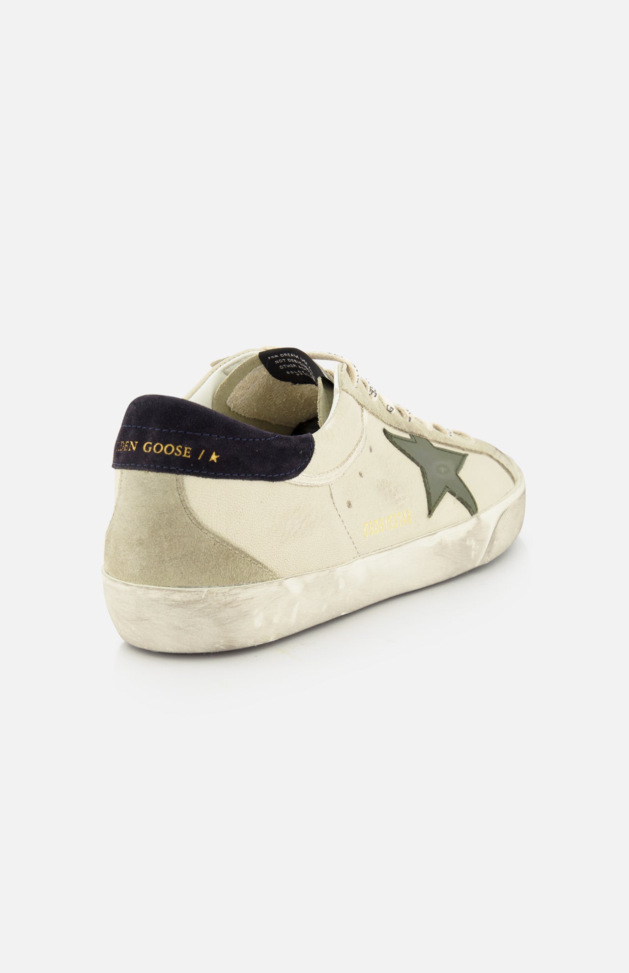 The GOLDEN GOOSE Super Star Nappa Upper Suede Sneaker, in beige with a dark green star, black heel tab with gold text, white laces, and a distressed sole, is displayed on a white background.