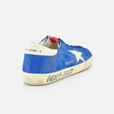 The GOLDEN GOOSE Super Star Suede Upper And Nylon Tongue Sneaker features a blue suede upper, white star, worn-in look, and "Golden Goose" on the side, with a white heel patch with black text and red inner detail for vintage style.