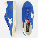 The GOLDEN GOOSE Super Star Suede Upper And Nylon Tongue Sneaker features vibrant blue suede, white star accents, and white soles; shown are a side view and a top view on a plain white background.