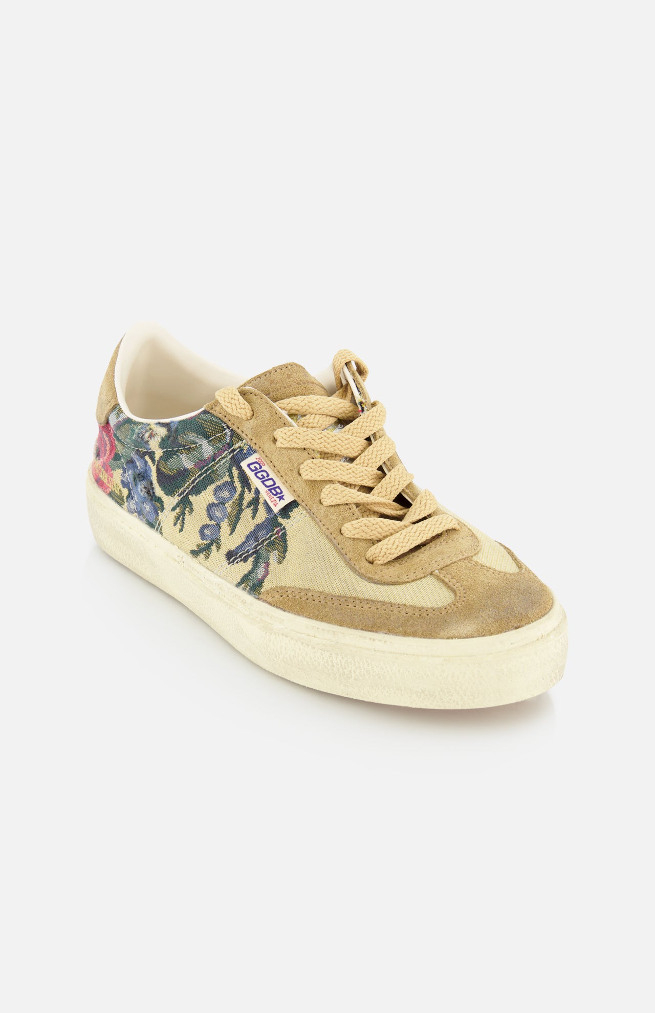 The Soul-Star Canvas Sneaker by GOLDEN GOOSE features tan suede, a cream sole, tan laces, and a botanical side print with a vintage style. A small purple-and-white label near the laces adds flair. Presented on a plain white background.