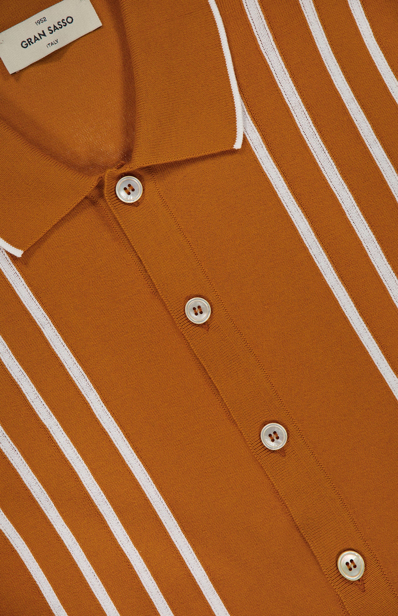 Close-up of the GRAN SASSO Button Up Knit Short Sleeve Shirt in brown with white vertical stripes, a collar trimmed with white piping, and four brown buttons. Label shows "Gran Sasso Italy.