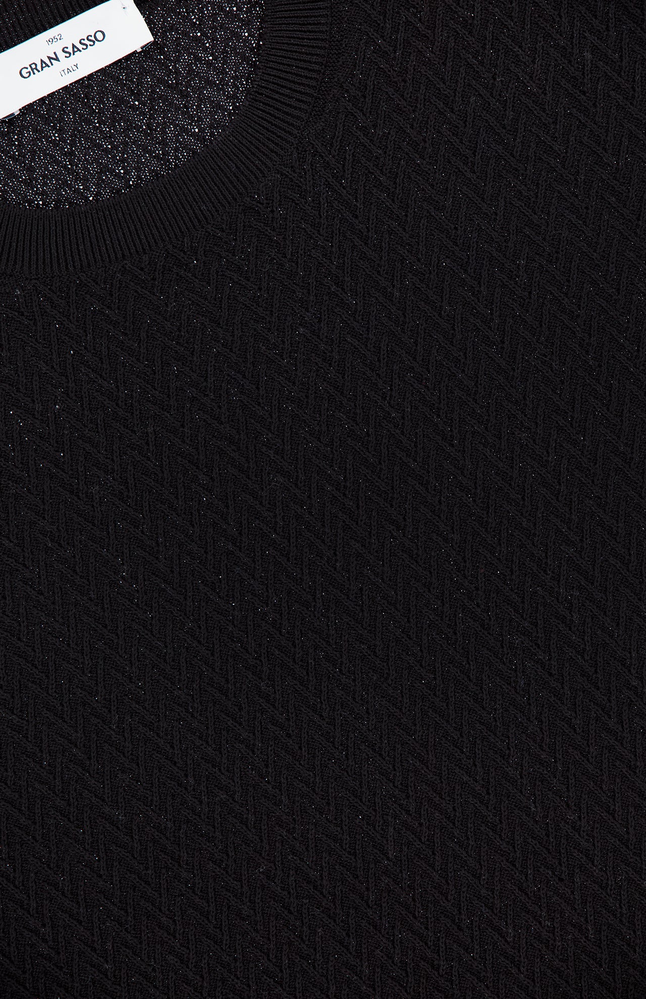 Close-up of the GRAN SASSO Crewneck Short Sleeve Sweater in black, featuring a subtle zigzag pattern, ribbed crew neck, and visible white brand label, showcasing its refined cotton pullover design.