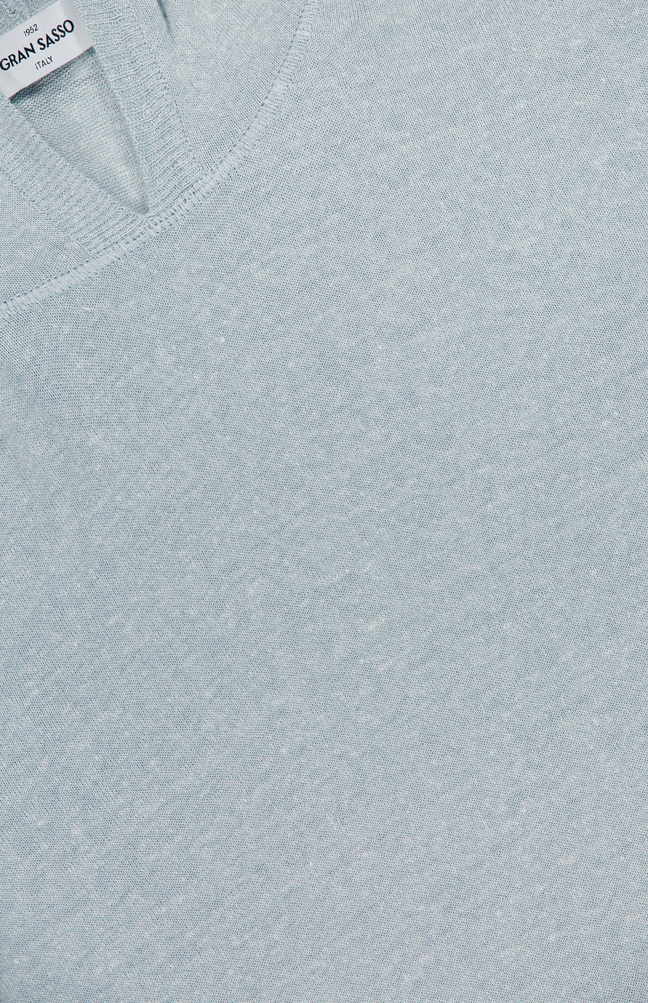 Close-up of GRAN SASSO's Knit Linen-blend Hoodie in pale blue, featuring a V-shaped neckline. A partially visible white label with black text appears at the top left.