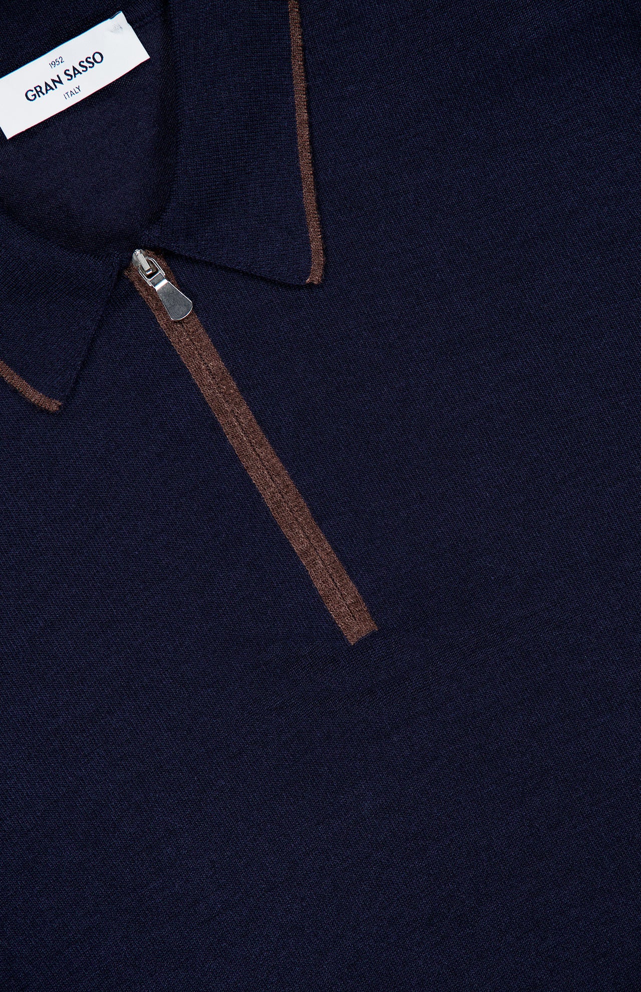 Close-up of a GRAN SASSO Quarter Zip Polo Sweater in navy blue, crafted in Italy, featuring a brown zipper and trim detail on the collar. The visible collar label emphasizes its premium wool-silk blend construction.