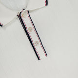 Close-up of the GRAN SASSO Stitch Detailing Polo Shirt in 100% cotton with a ribbed texture, collar, and three-button placket. Navy and red stitching trims the collar and placket; inner label reads GRAN SASSO Italy.