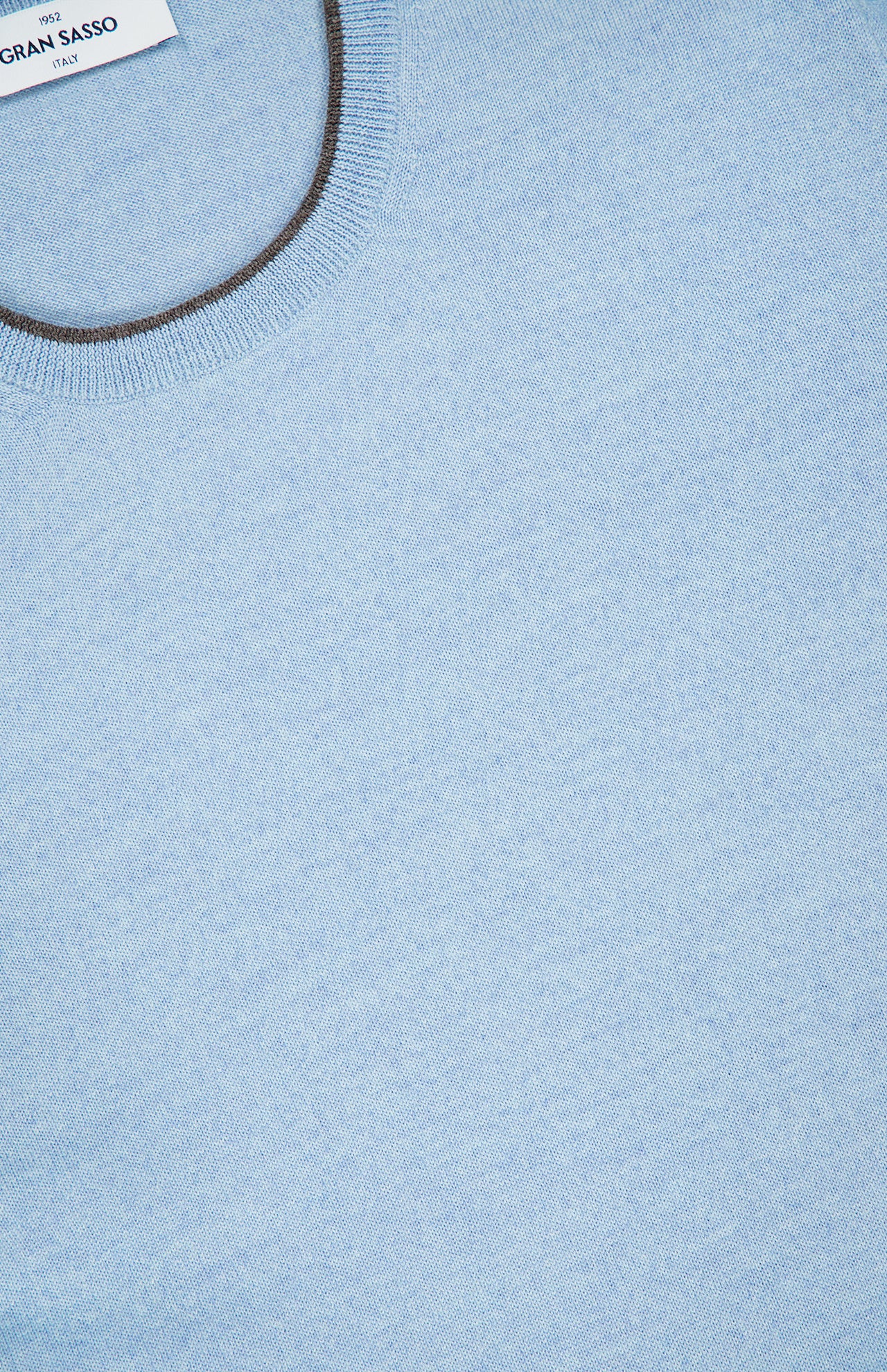 Close-up of the GRAN SASSO Suede Elbow Patch Crewneck Sweater in light blue, highlighting the collar and the finely knit texture crafted from soft virgin wool. A small white clothing label with text is visible near the neckline at the top left.