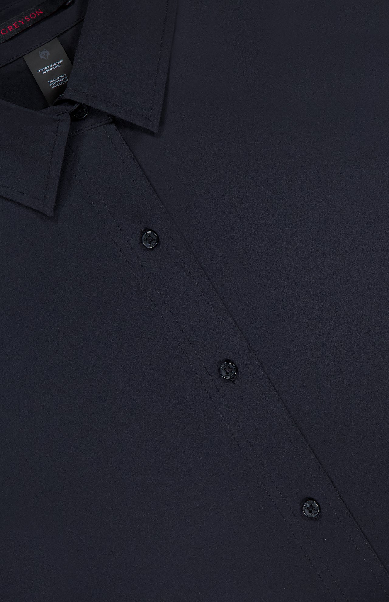 Close-up of the GREYSON Ashe Button Down Shirt in dark navy, showcasing its collar, button placket, and three buttons against a plain background, emphasizing its tailored design.