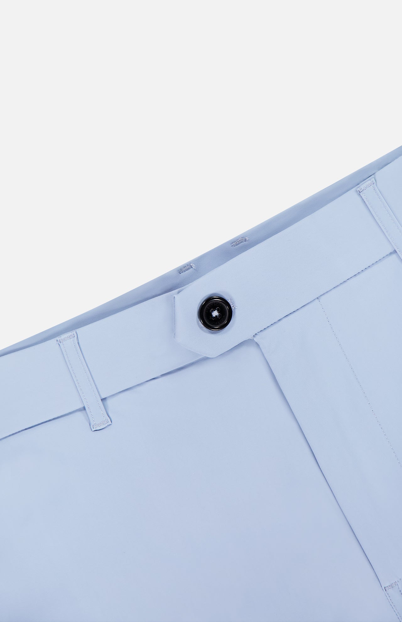 Close-up of the GREYSON 8 Inch Montauk Short’s waistband in light blue, showing a black button, belt loops, and stitching. Crafted from stretch breathable fabric for comfort and style, set against a white background.