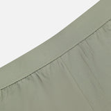Close-up of the waistband and upper section of GREYSON Arenac Perforated Sport Short in light green, featuring an elasticized back, smooth front, detailed stitching, and a zip pocket—ideal for those seeking breathable performance.