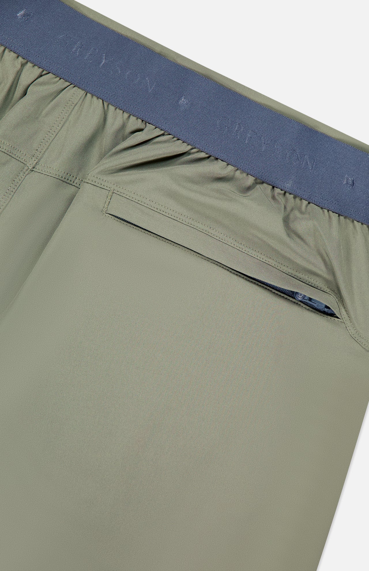 Close-up of the back of GREYSON Arenac Perforated Sport Short in dark green, highlighting the breathable fabric, dark gray elastic waistband with subtle branding, and a zip pocket for essentials.