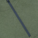 Close-up of the GREYSON Calgary Quarter Zip Hoodie Sweater in green, featuring a black zipper running vertically down the front. The top edge of the zipper reveals a glimpse of camouflage-patterned fabric beneath, while breathable yarns provide comfort and thermal insulation.