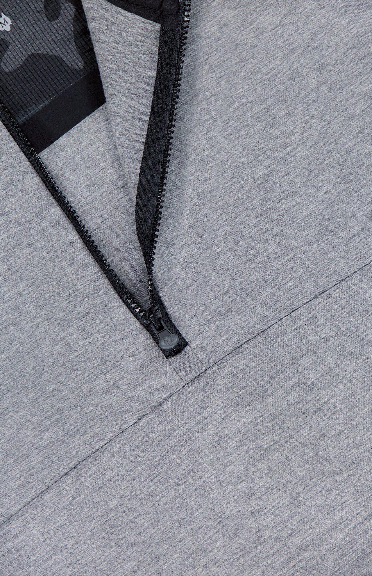 Close-up of the GREYSON Calgary Quarter Zip Sweatshirt in grey, featuring a partially unzipped black zipper that reveals black mesh lining with a subtle camo pattern—crafted for thermal insulation and understated style.